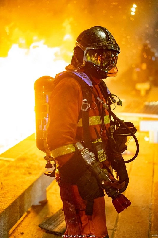 Bombero con equipo de respiración frente a un incendio